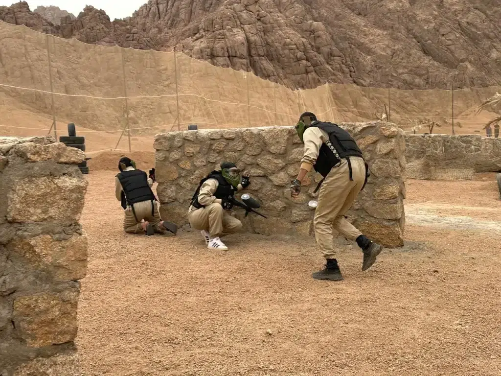 Paintball player in action shooting during an intense game in the desert