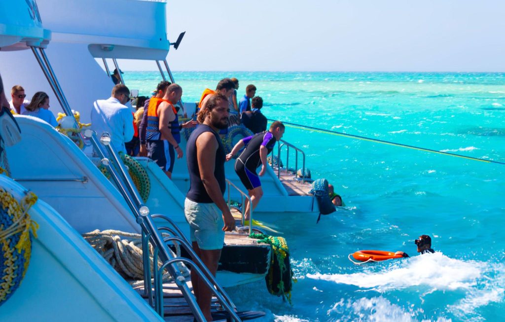Group of divers entering the water from the boat at White Island Sharm El Sheikh